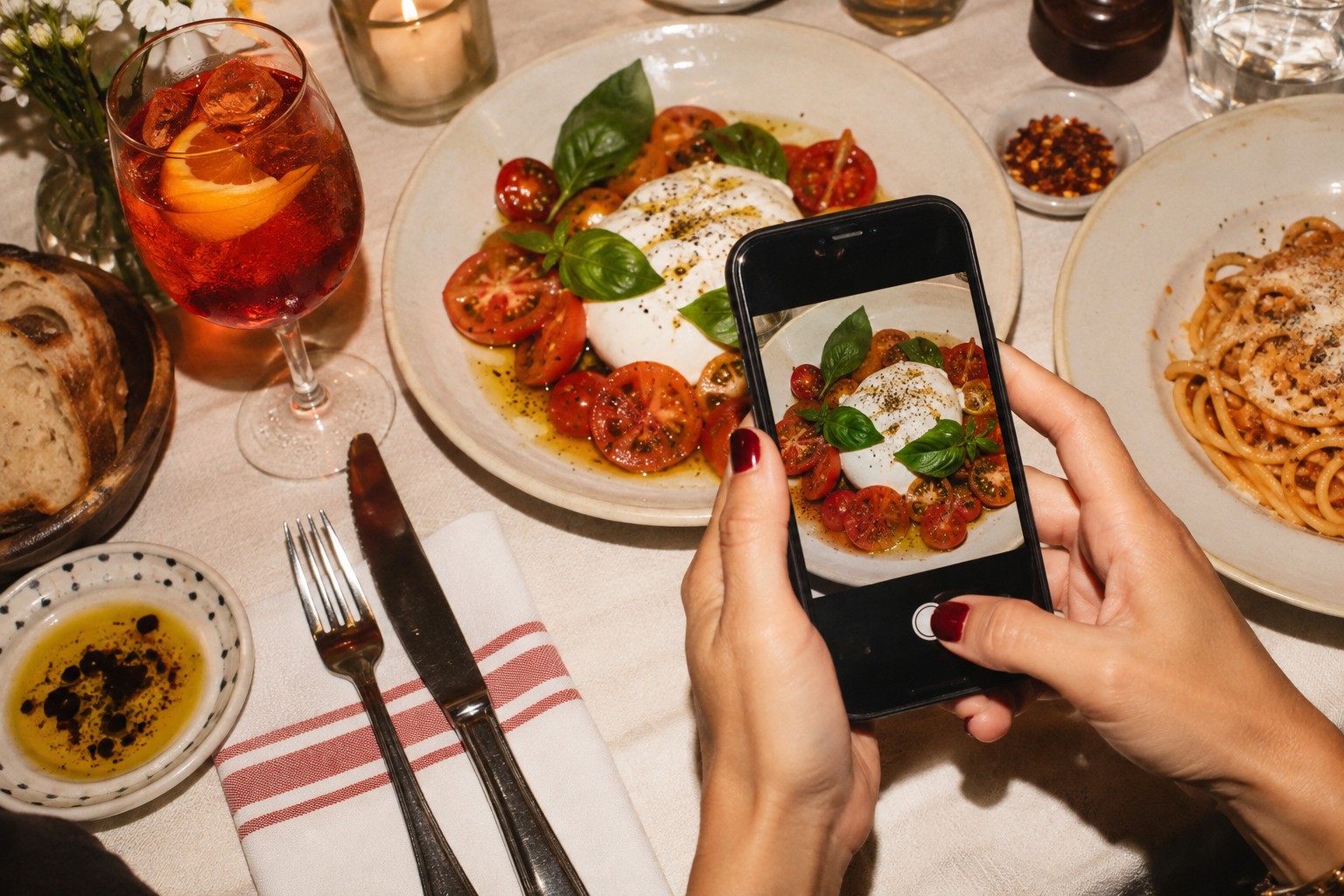 A food creator photographs a restaurant meal for social content